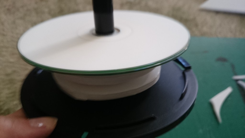 The extra layers added to the spindle and free turning CD on the top which would spin against the one of the base